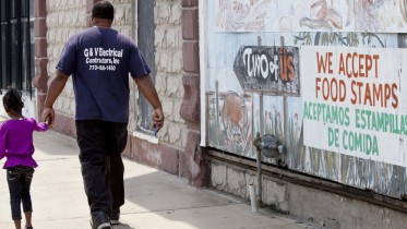 HARVEY, IL - AUGUST 19: A sign painted on top of a mural says 'We accept food stamps,' on August 19, 2013 in Harvey, Illinois. Harvey is a depressed suburb of Chicago that has been hit even harder by the sluggish economy. The suburban poor also have challenges getting services that can help them. Buildings all over town are boarded up - whether they be single family homes or businesses. (Photo by Melanie Stetson Freeman/The Christian Science Monitor via Getty Images)